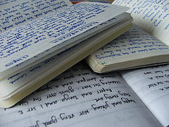 Image of several open paper notebooks open on top of one another